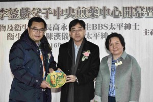 图二：食物及衞生局局长高永文医生BBS太平绅士(中)，由东华三院主席何超蕸小姐(右)陪同，代表东华三院致送纪念品予捐款人李鋈麟博士太平绅士(左)。
