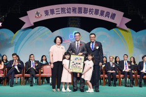 东华三院副主席李鋈麟博士太平绅士（后排右一）陪同东华三院副主席兼学务委员会副主任委员文颖怡女士（后排左一）致送纪念品予主礼嘉宾教育局副局长杨润雄太平绅士（后排中）。