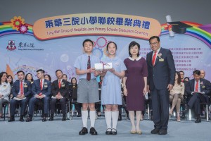 东华三院主席兼名誉校监李鋈麟博士太平绅士(右一)陪同主礼嘉宾教育局常任秘书长黎陈芷娟太平绅士(右二)颁发毕业证书予毕业学生代表。