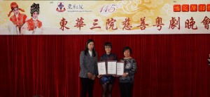 东华三院主席何超蕸小姐(右)、筹委会主席暨东华三院总理洪若甄女士(左)一同致送感谢状予鸣芝声剧团台柱盖鸣晖小姐(中)。