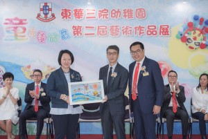 东华三院副主席兼学务委员会主任委员文颖怡小姐（左）在东华三院主席兼校监李鋈麟博士太平绅士（右）陪同下致送纪念品予教育局首席助理秘书长（幼稚园教育）胡振声先生（中）。