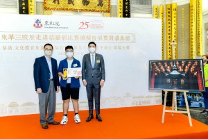 图2： 文化体育及旅游局局长杨润雄先生GBS太平绅士(左)及东华三院主席马清扬先生(右)向正就读东华三院陈兆民中学的学生组冠军刘子韬(中)颁发奖座。