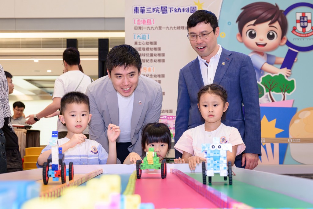 图二为本院副主席伍怡先生（左二）和候任教育科主管林文杰先生（右一）与小朋友一起进行赛车比赛。