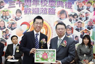 东华三院主席兼名誉校监梁定宇（左）致送纪念品予教育局首席教育主任任衞沛。