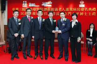 民政事务局常任秘书长杨立门太平绅士(右三)，在医院管理局港岛西医院联网总监陆志聪医生(左二)、东华三院梁定宇主席(左三)、医院管理局港岛西医院联网社区医护服务统筹专员陈汉威医生(左一)及谭国翘总理夫人(右一) 陪同下，致赠纪念品予谭国翘总理(右二)。