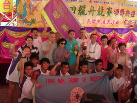 东华三院张佐华主席（手持奖杯者）与东华三院冯黄凤亭中学龙舟队成员一同领取「小龙邀请赛沙田区少年警讯名誉会长会-反青少年吸食危害精神毒品杯」冠军奖杯。