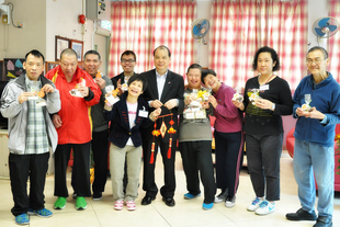 劳工及福利局局长张建宗GBS太平绅士（右五）探访东华三院恒毅工场暨宿舍，张局长向会员送赠贺年曲奇，舍友亦回赠亲手制作的贺年珠艺吊饰。