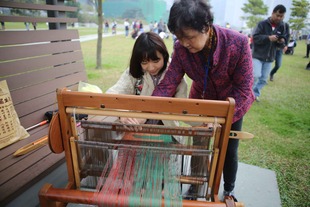 拥有传统织鱼网技术的婆婆正在示范和教授编织鱼网。