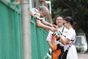 超过八千名学生，以及贴有卖旗人员证的志愿者热心支持东华三院卖旗日2014，于8月27日在全港各区向市民劝销东华纸旗。