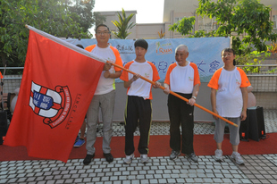 东华三院主席施荣恒先生(左一)在誓师大会上授旗予运动员代表区俊华(左二)、谢玉成(右二)及苏洁萍，为他们打气。