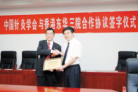 梁定宇主席（左）致送纪念品予中医药管理局于文明副局长。