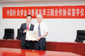 梁定宇主席（左）与中国针灸学会会长李维衡教授签订合作协议。