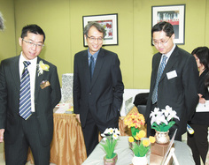 梁定宇主席（左）、劳工及福利局常任秘书长邓国威太平绅士（中）参观「希望户口」妇女亲手制作的工艺品。
