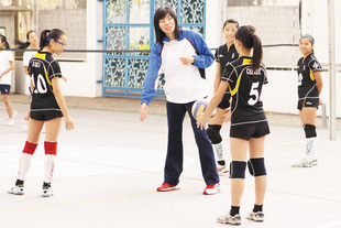 张萍细心地指导女子排球队队员。