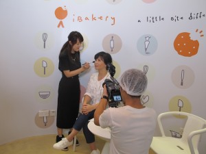 东华三院社会企业i+o全面美型格影楼化妆师Crystal（左一）为苏玉华补妆。