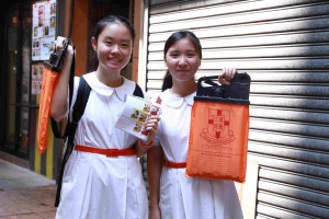图十二及十三为炎热的天气阻挡不了志愿者的爱心，多达12,000名志愿者参与东华三院卖旗日。