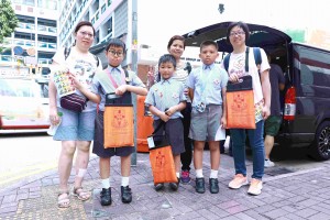图十二及十三为炎热的天气阻挡不了志愿者的爱心，多达12,000名志愿者参与东华三院卖旗日。