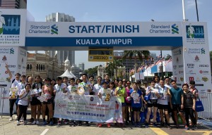 东华三院iRun跑手及伴跑员在「2019吉隆坡渣打马拉松」起步拱门前合照