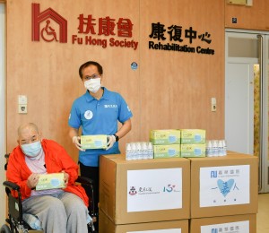 嘉华国际工程策划总监 (香港地产) 黄博强先生(右)将医用口罩送予扶康会康复中心的服务使用者代表