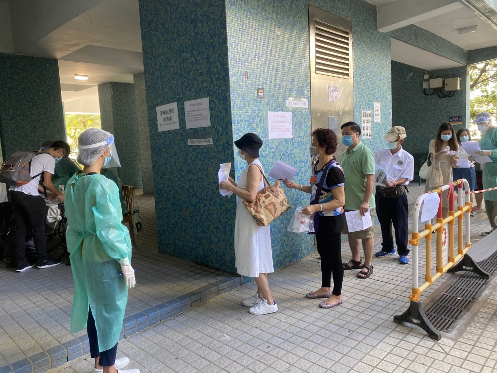 图七及图八：东华三院调配工作人员在检测站协助收集检测瓶。