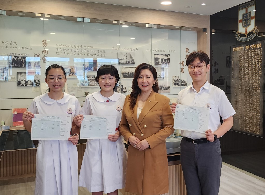 图一为东华三院主席兼校监邓明慧女士(右二)祝贺三位考获DSE佳绩的同学─梁萦牵同学(左一)、徐艺瑞同学(左二)及孙啓畯同学(右一)。