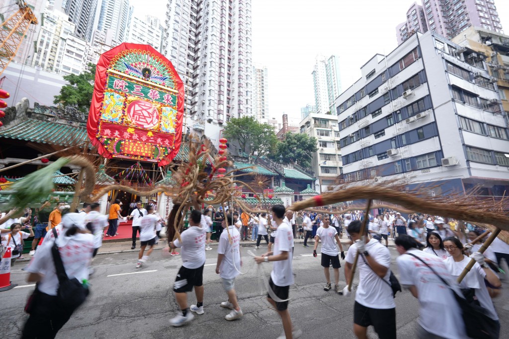 图四为由薄扶林村火龙会带来的百尺火龙穿梭于上环街道，气势磅礴，成为出巡队伍中最瞩目的焦点之一。